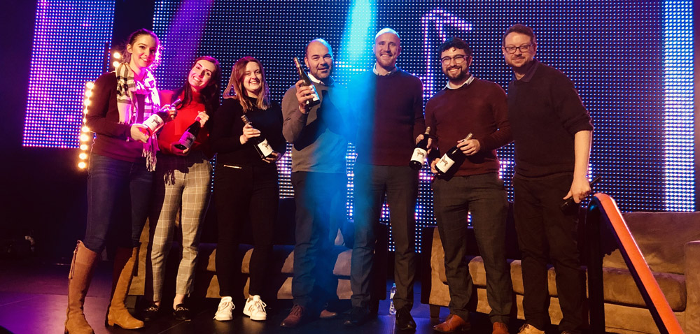 People standing on the stage holding wine