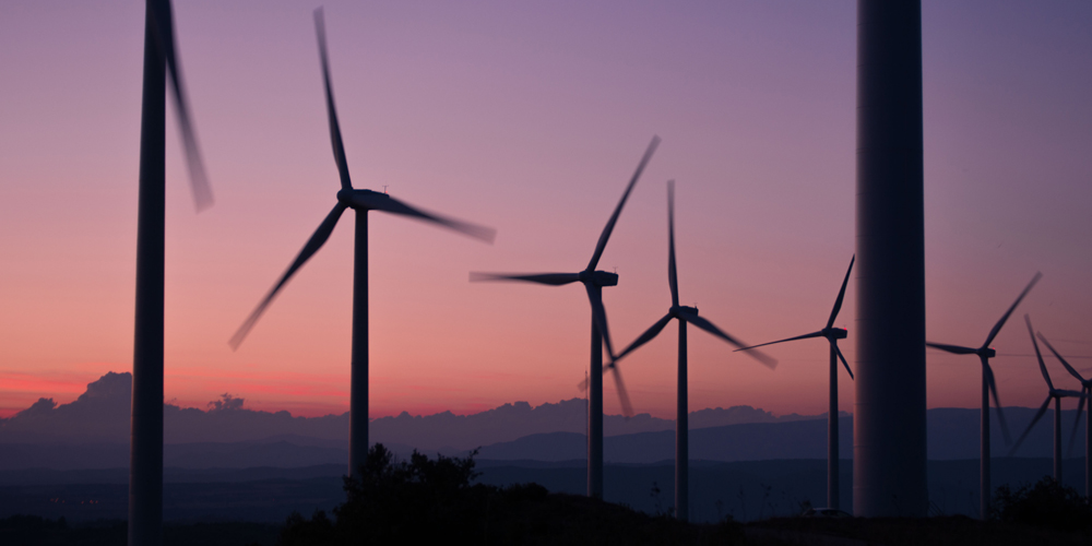 Wind turbine against purple sky